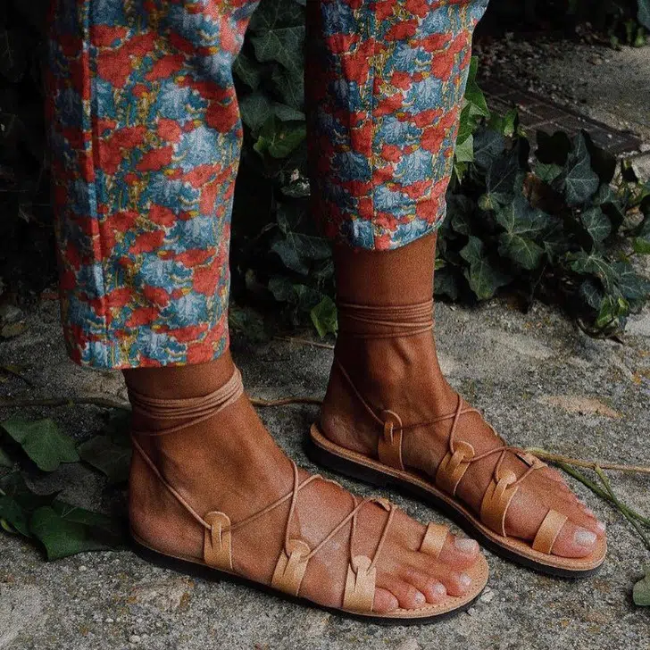 Модель в кожаных сандалиях в греческом стиле с тонкими ремешками от Sandalias Griegas