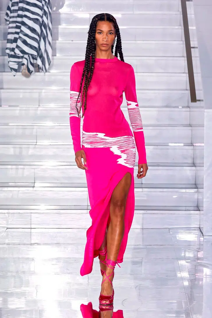 Модель в розовом платье с длинными рукавами и глубоким разрезом, и модных босоножках