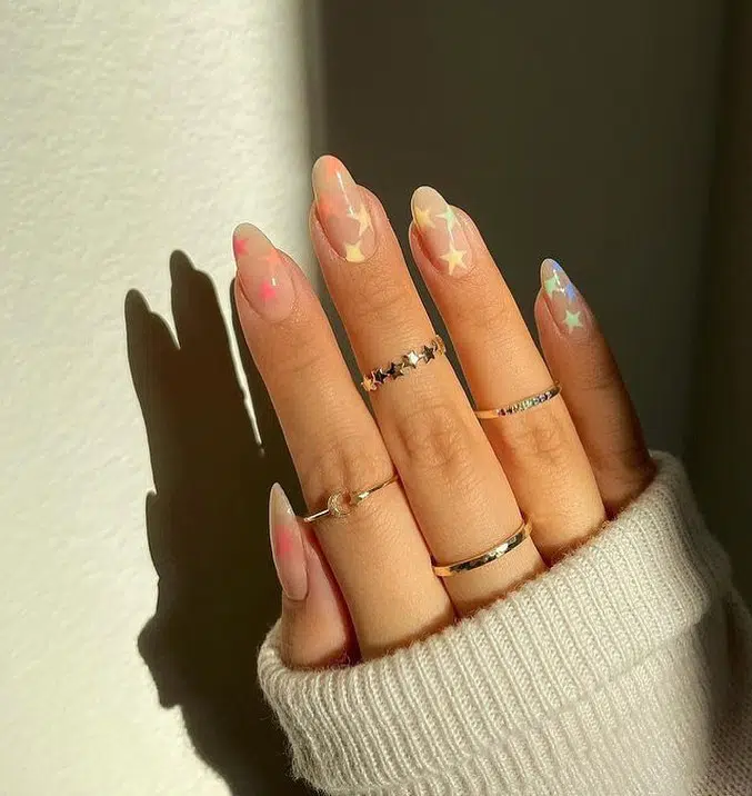 Натуральный маникюр с разноцветными пастельными звездами на миндальных ногтях