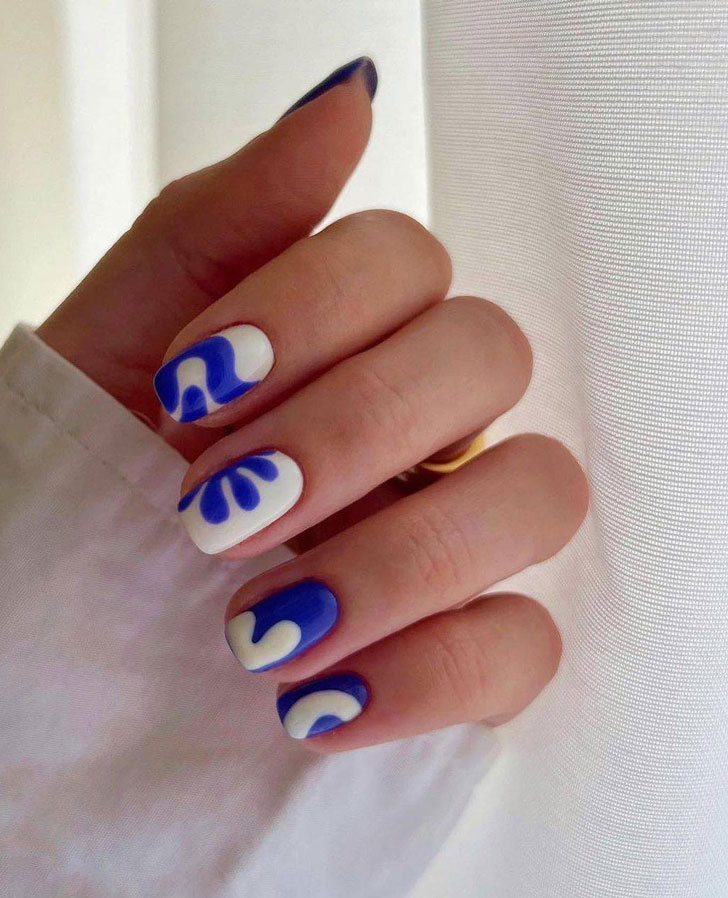 Яркий бело-синий маникюр с принтом на ухоженных квадратных ногтях