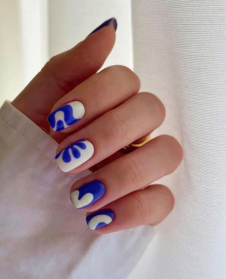 Яркий бело-синий маникюр с принтом на ухоженных квадратных ногтях