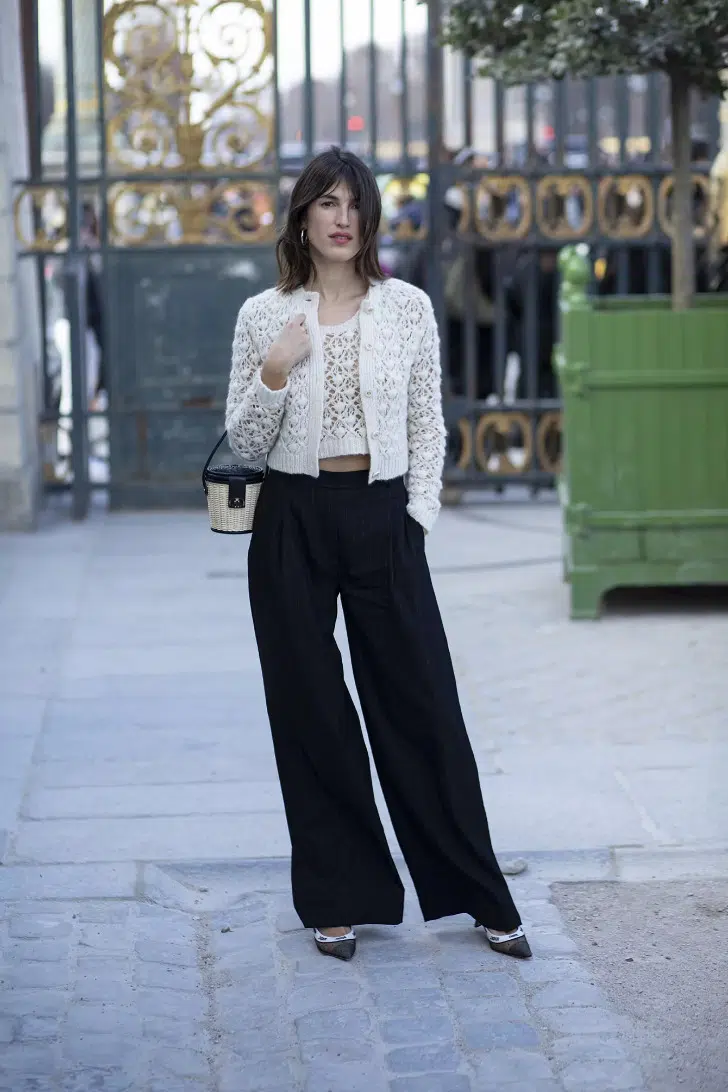 Жанна Дамас в широких черных брюках, вязаном жакете и топе молочного цвета