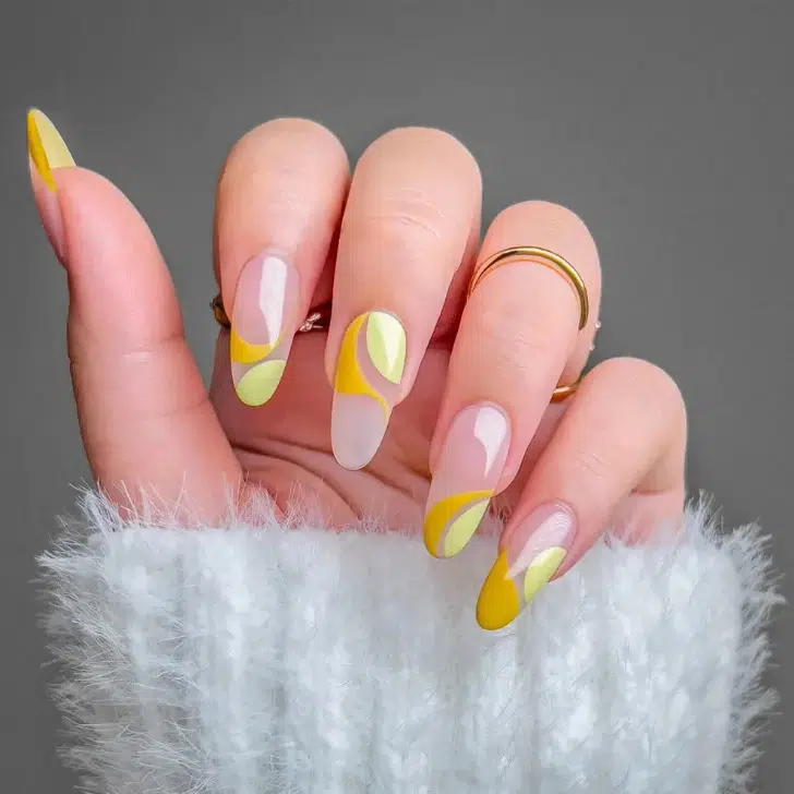Желтый маникюр с завитками на длинных овальных ногтях