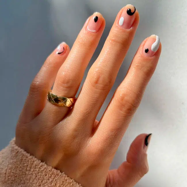 Черно-белый абстрактный маникюр с точками и завитками на ухоженных ногтях