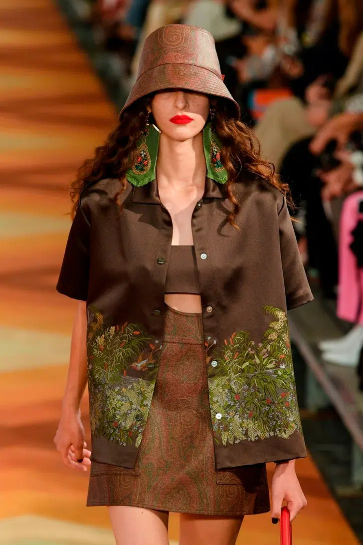 Модель в мини юбке, коричневой блузке с вышивкой и шляпе ведро от Etro