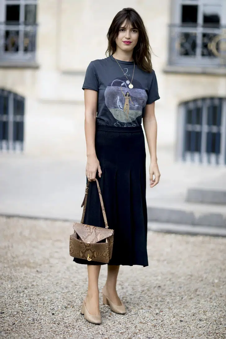 Жанна Дамас в черной юбке миди, серой футболке с принтом и бежевых туфлях на невысоком каблуке