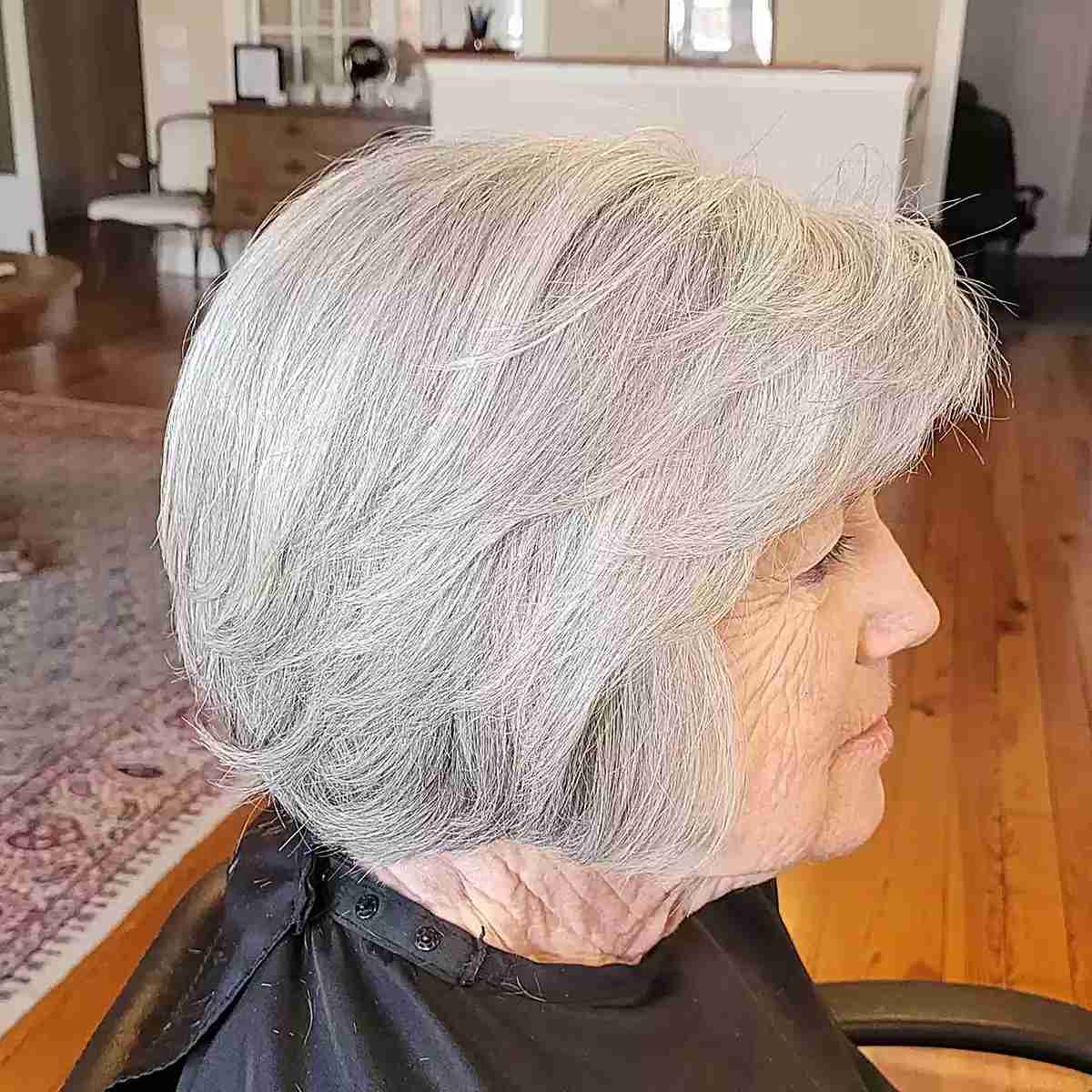 Женщина с многослойной стрижкой боб с боковой челкой на седых натуральных волосах