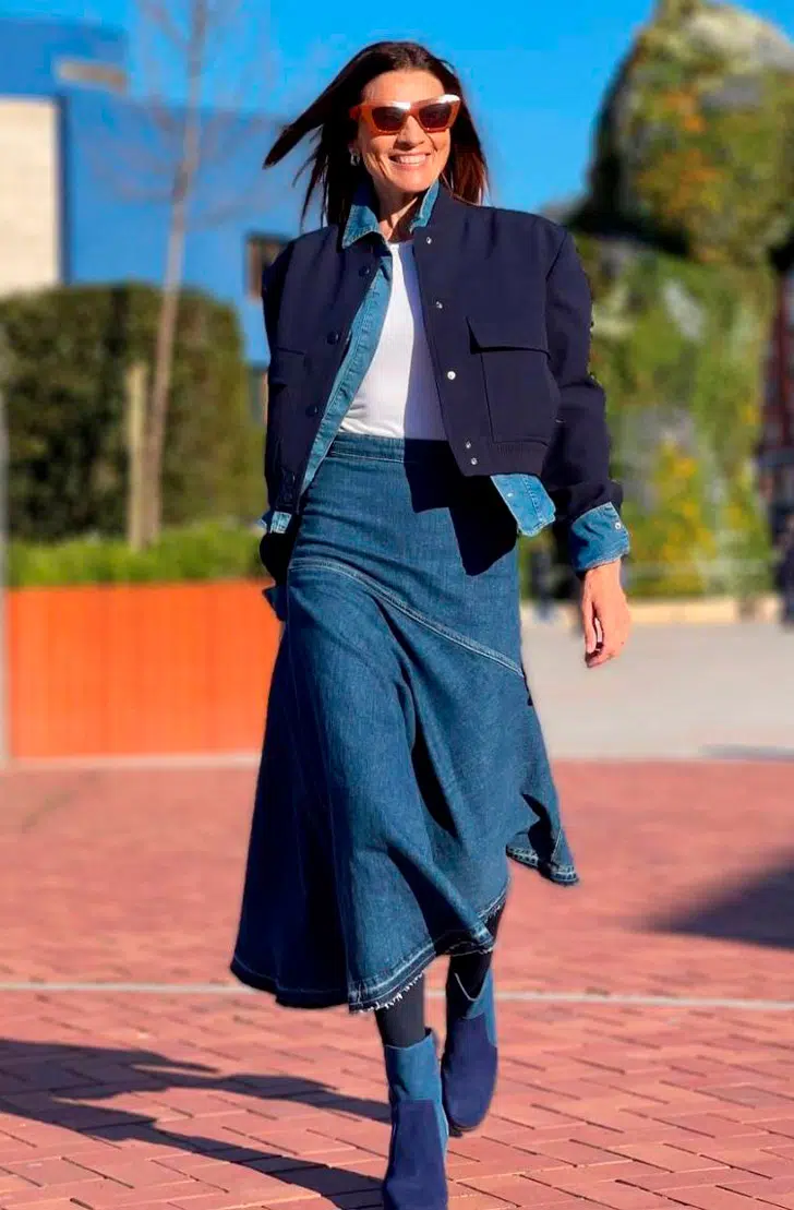Женщина в джинсовой юбке миди, синей короткой куртке и ботильонах на каблуке