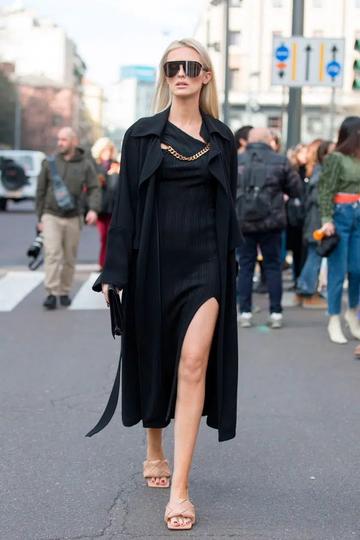 Девушка в черном платье и бежевых босоножках на невысоком каблуке