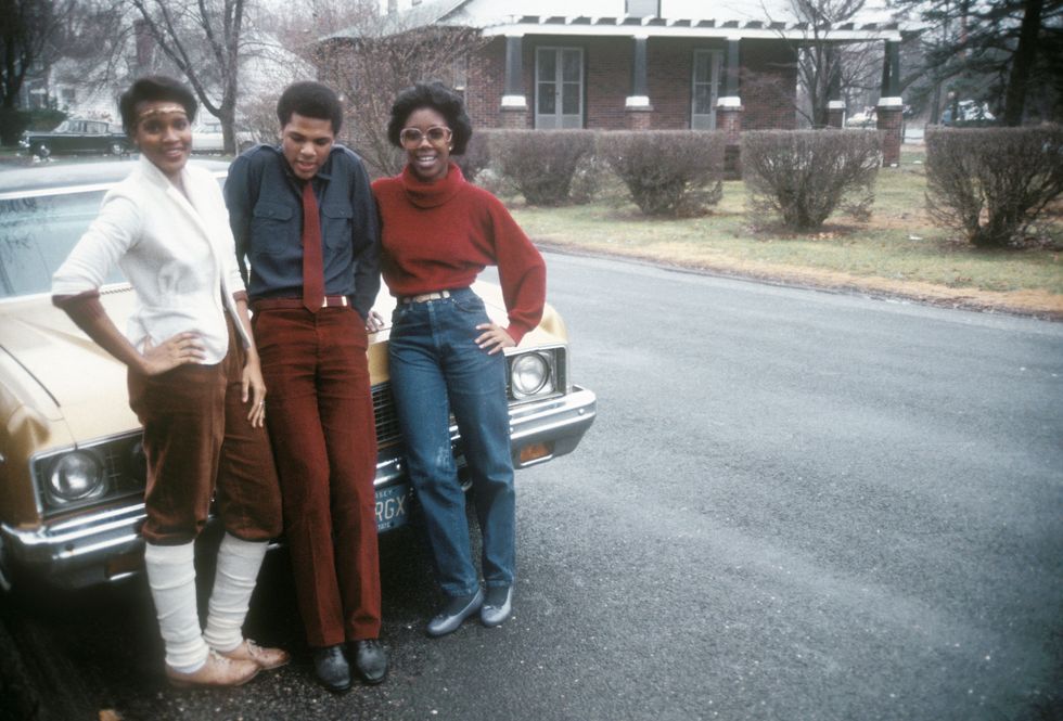 Девушка в джинсах мом с ремнем и красном свитере - 1980 год