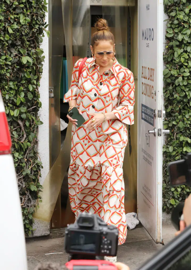 Дженнифер Лопес в платье с крано-оранжевым принтом выходит из ресторана