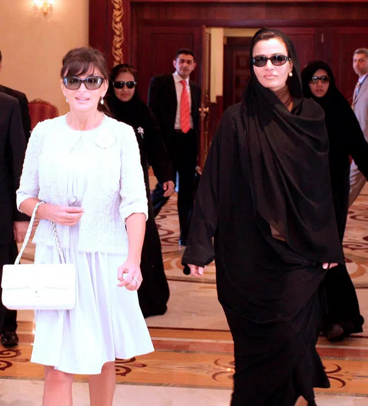 Моза бинт Насер в черном свободном платье с платком и солнцезащитных очках
