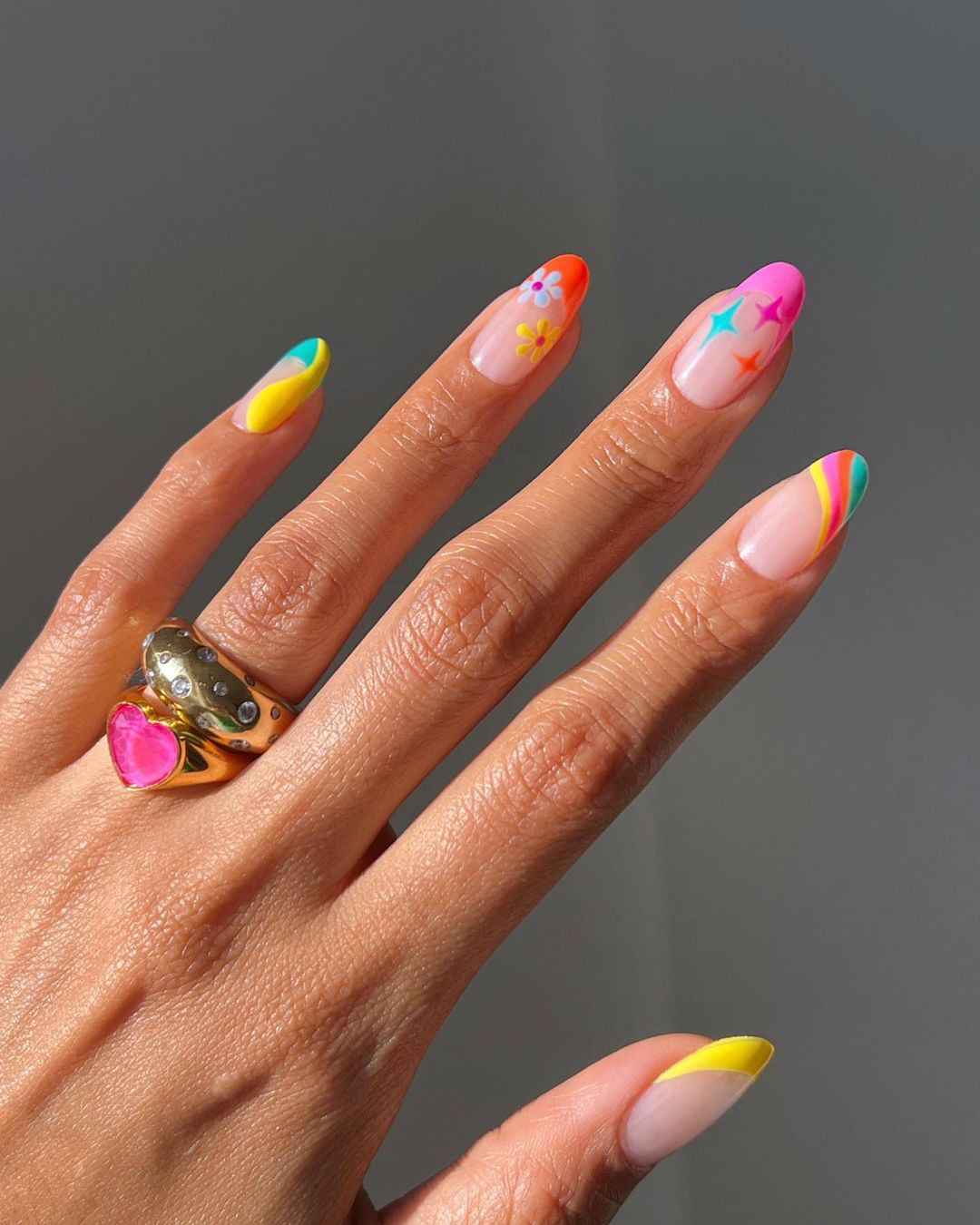 Разноцветный френч с яркими принтами на овальных ногтях средней длины