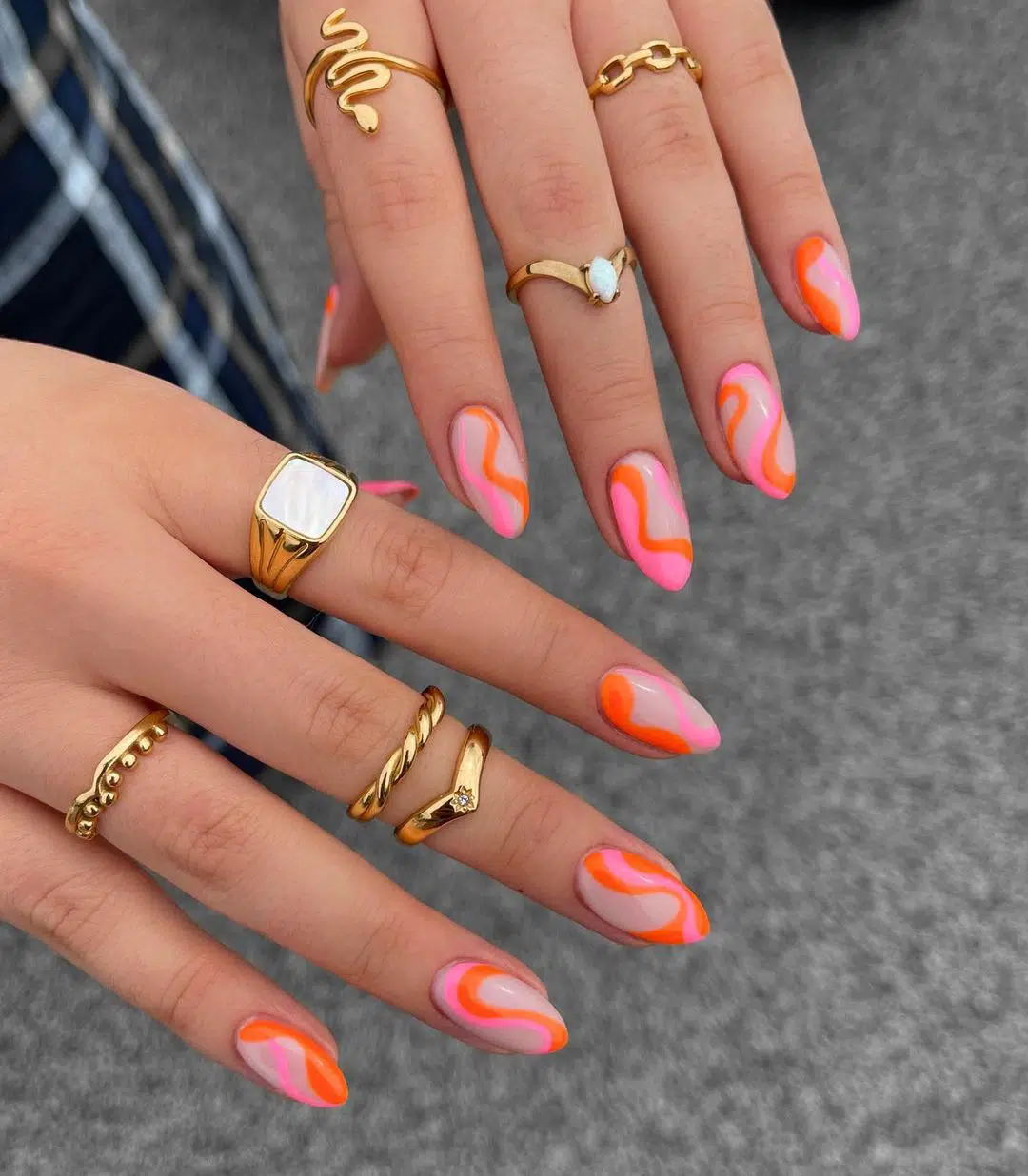 Яркий розово-оранжевый маникюр с завитками на ухоженных миндальных ногтях