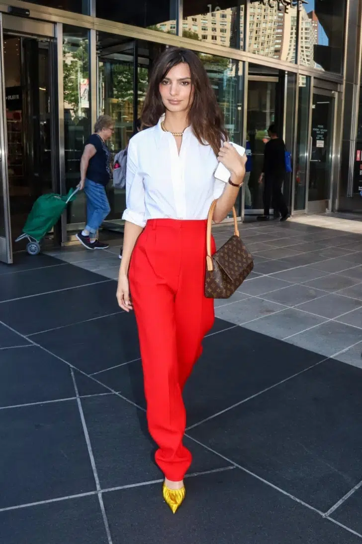 Эмили Ратаковски в красных брюках, белой рубашке и с сумочкой от Louis Vuitton