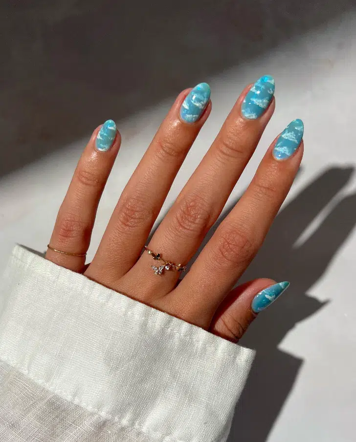 Голубой маникюр с облаками на овальных ногтях средней длины