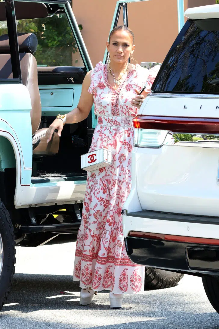 Дженнифер Лопес в длинном платье, украшенном красным цветами и сумкой-контейнером