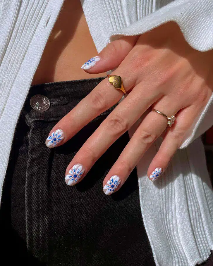 Маникюр с белыми тропическими цветами на овальных ухоженных ногтях