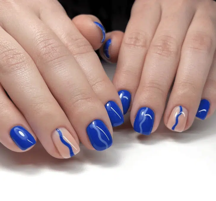 Синий маникюр с волнообразными линиями на коротких натуральных ногтях