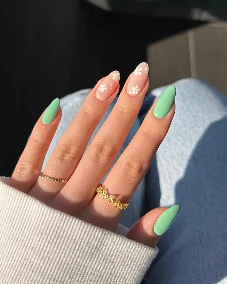 Зеленый пастельный маникюр с белыми ромашками на овальных ногтях