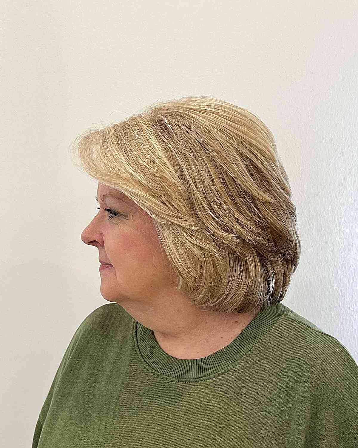 Женщина со стрижкой многослойный боб с боковой челкой на объемных волосах