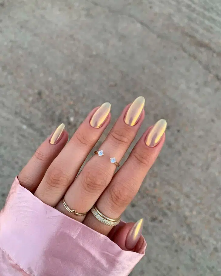 Золотой металлизированный маникюр на овальных ногтях средней длины