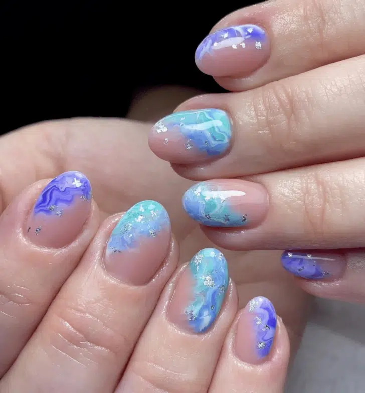 Голубой маникюр с блестками и волнами на коротких овальных ногтях
