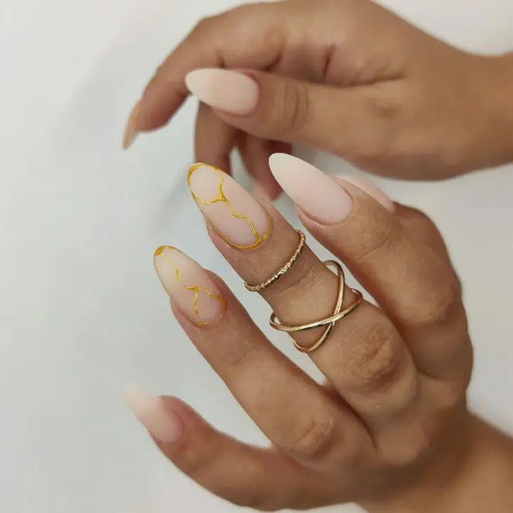 Матовый маникюр омбре с золотыми узорами на длинных миндальных ногтях