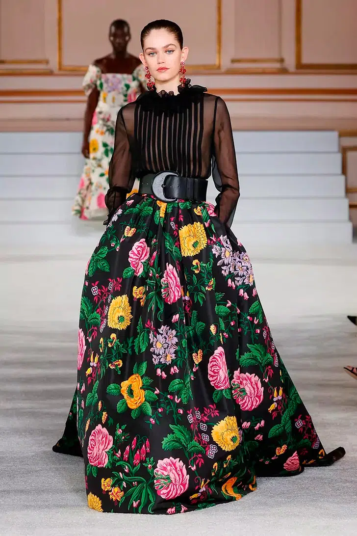 Модель в черной блузке и длинной юбке с цветочным принтом от Carolina Herrera