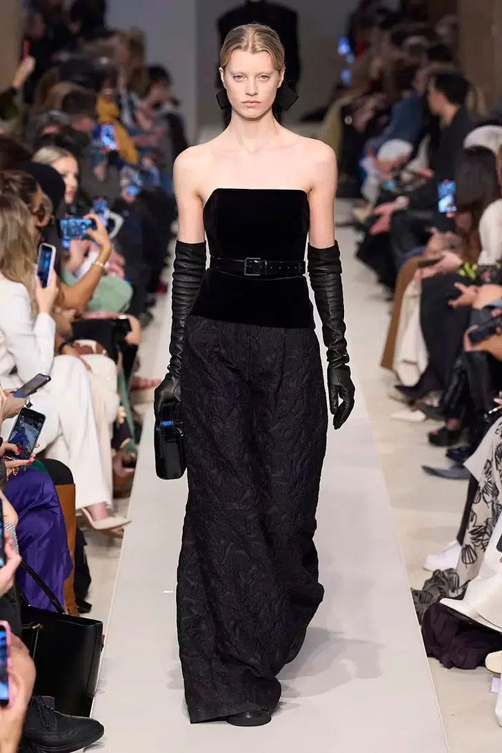 Модель в черном длинном платье с бархатным топом и высоких перчатках от Max Mara