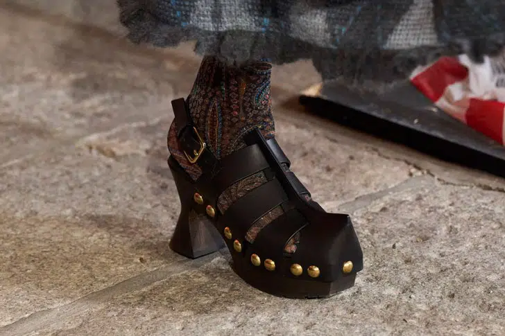 Модель в черных сандалиях на каблуке с золотыми заклепками от etro