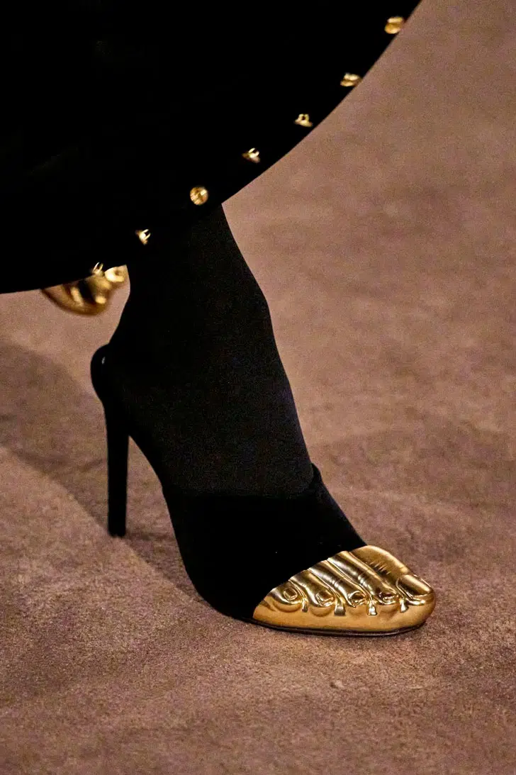 Модель в черных туфлях на шпильке с золотым носком от schiaparelli