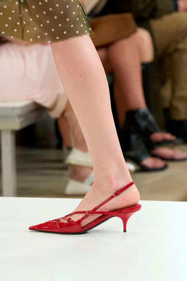 Модель в красных туфлях на низком каблуке с ремешками от miu miu