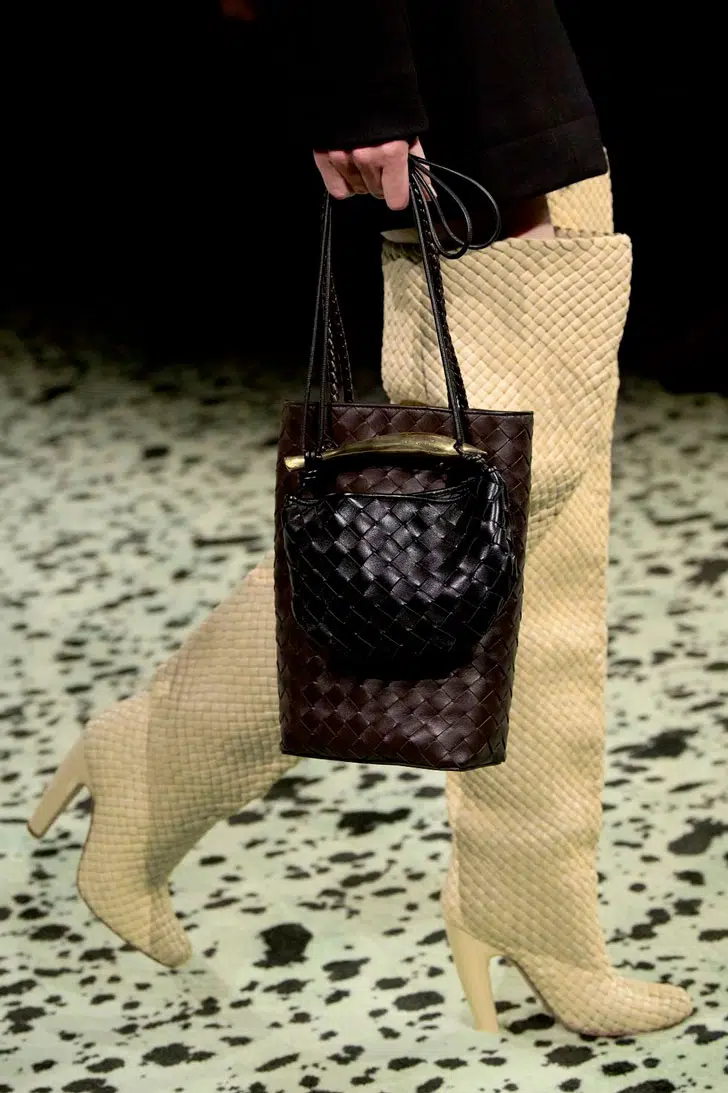 Модель в высоких плетенных сапогах бежевого цвета на каблуке от bottega veneta