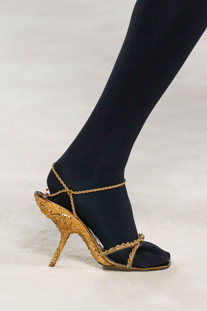 Модель в золотых босоножках на шнуровке и шпильке от ferragamo