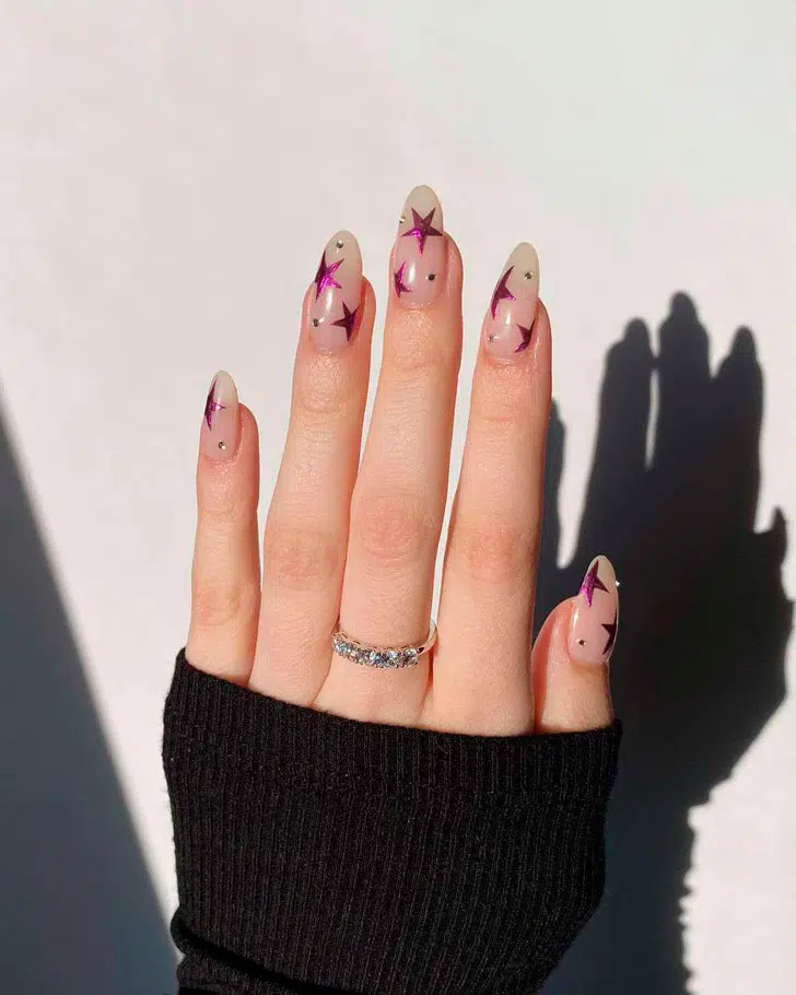 Натуральный маникюр с металлизированными розовыми звездами овальных ногтях