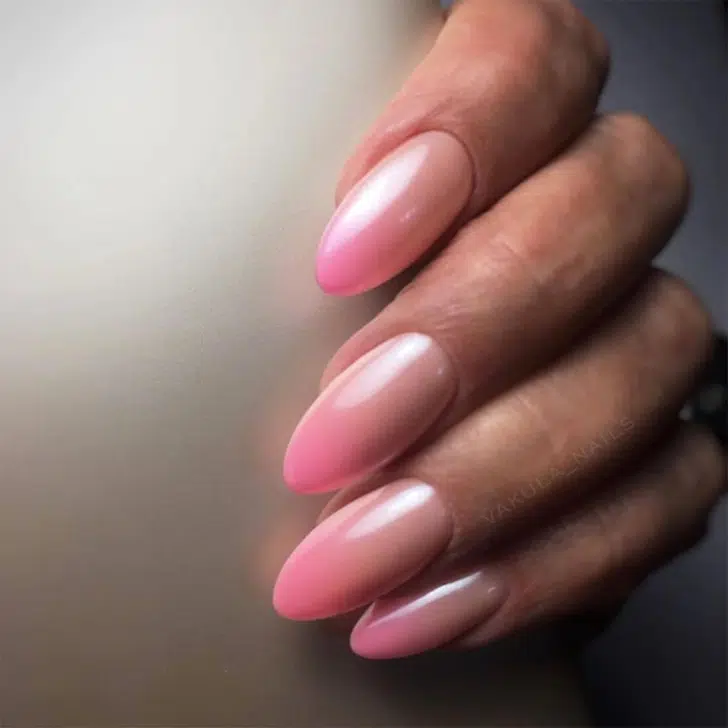 Розовый маникюр омбре с жемчужным покрытием на миндальных ногтях средней длины