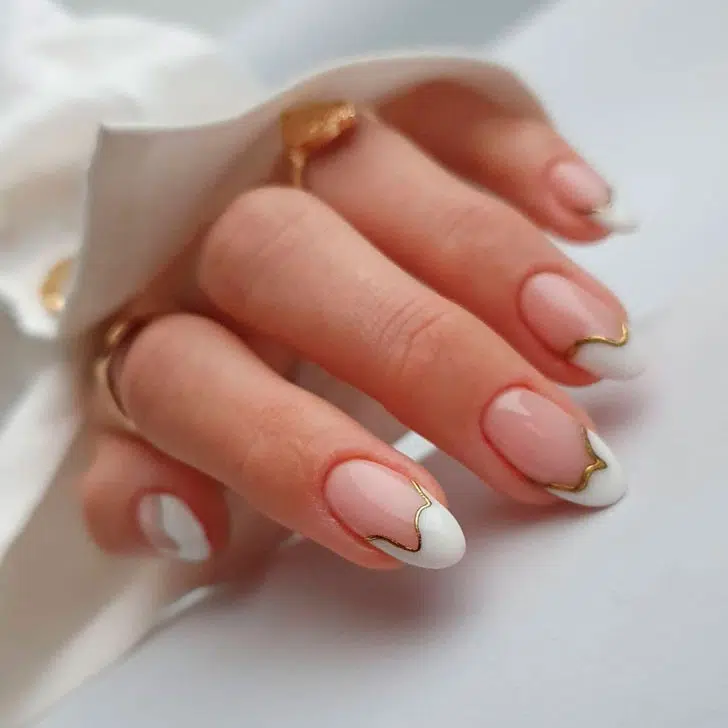 Абстрактный белый френч с золотом на овальных ногтях средней длины