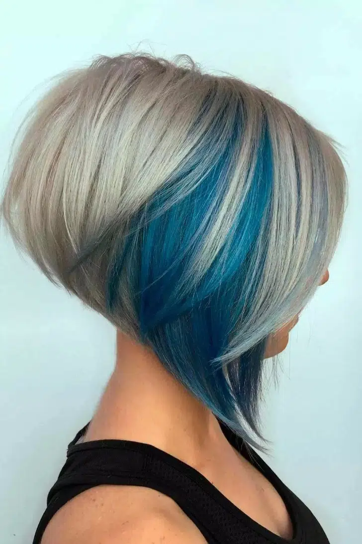 Девушка со стрижкой боб с синим скрытым окрашиванием на объемных светлых волосах
