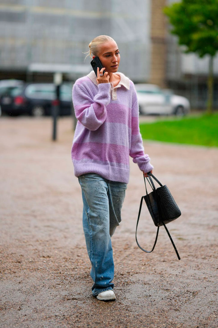 Девушка в мешковатых джинсах, фиолетовом свитере оверсайз и ботинках
