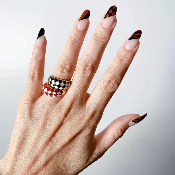 Диагональный черный маникюр с коричневым принтом на длинных миндальных ногтях
