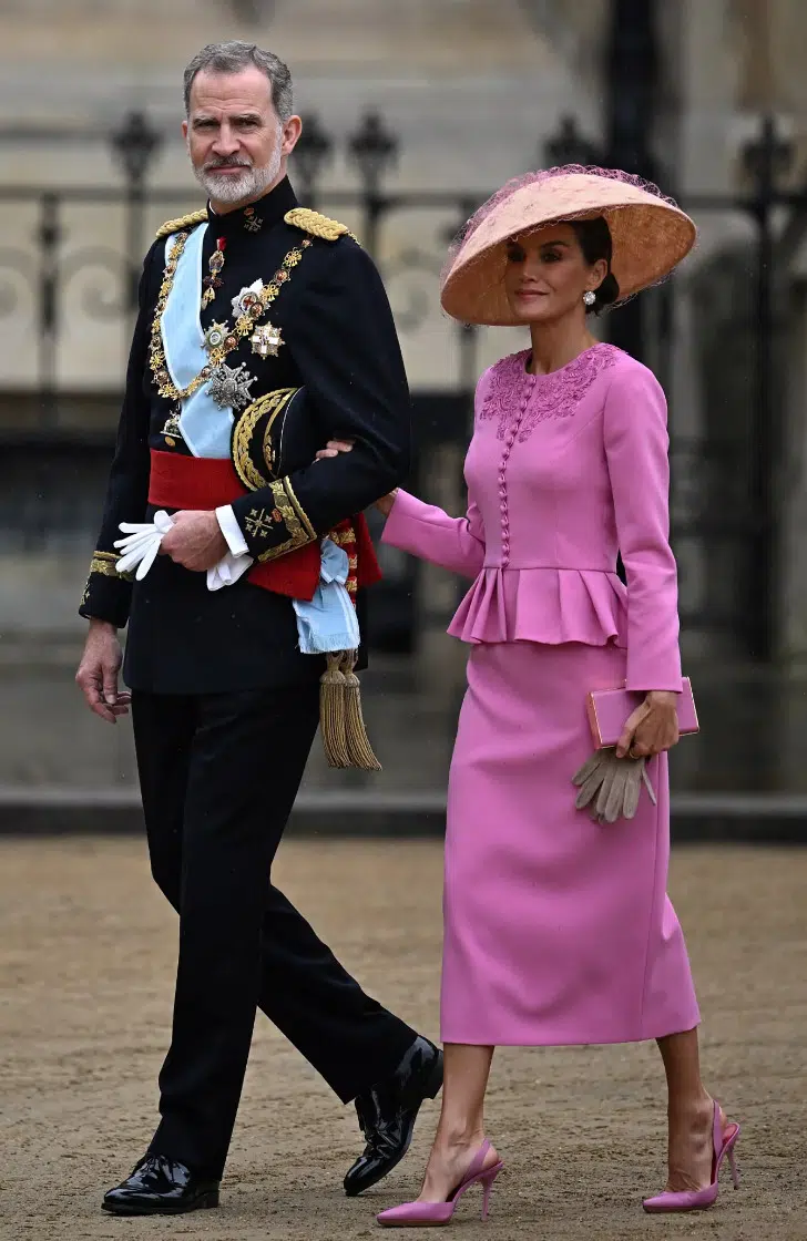 Королева Летиция в розовом костюме с узкой юбкой миди и оригинальной шляпке