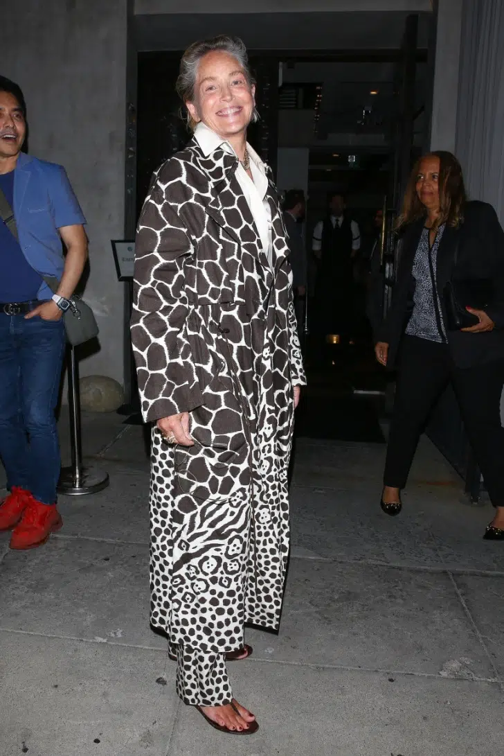 Шерон Стоун в пальто с принтом жирафа и сандалиях на плоской подошве