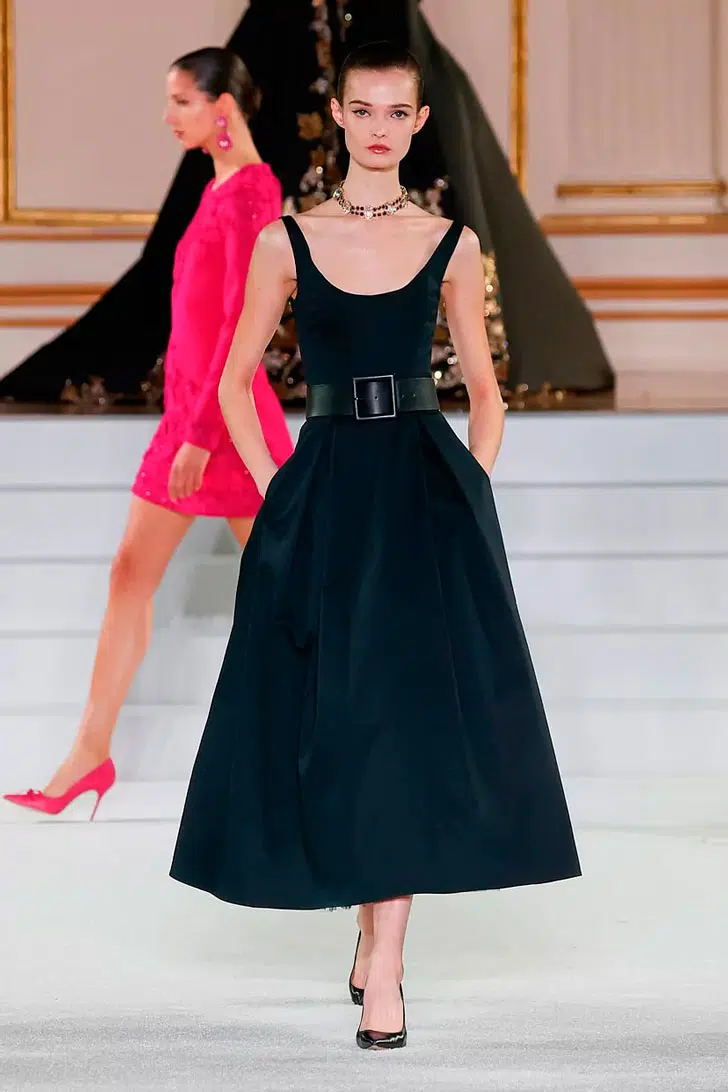 Модель в черном платье миди с пышной юбкой и черных туфлях от Carolina Herrera