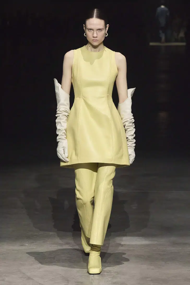 Модель в кожаном платье мини и высоких бежевых перчатках от Jil Sander