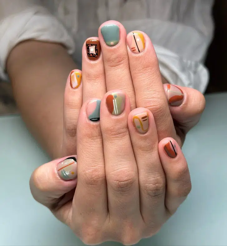 Осенний маникюр с разноцветными узорами на коротких ногтях
