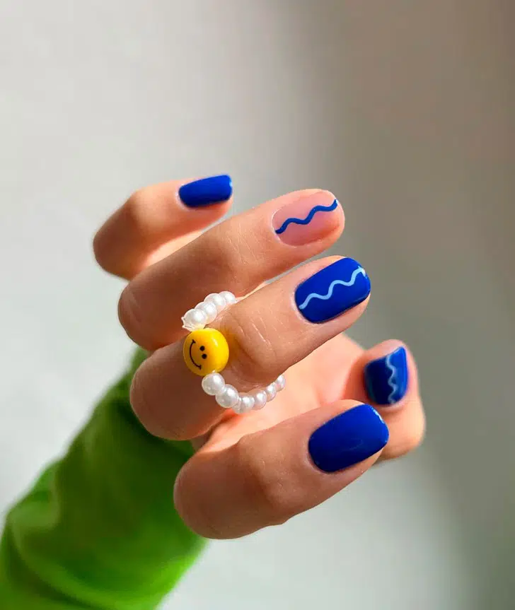 Синий маникюр с контрастными завитками на коротких натуральных ногтях