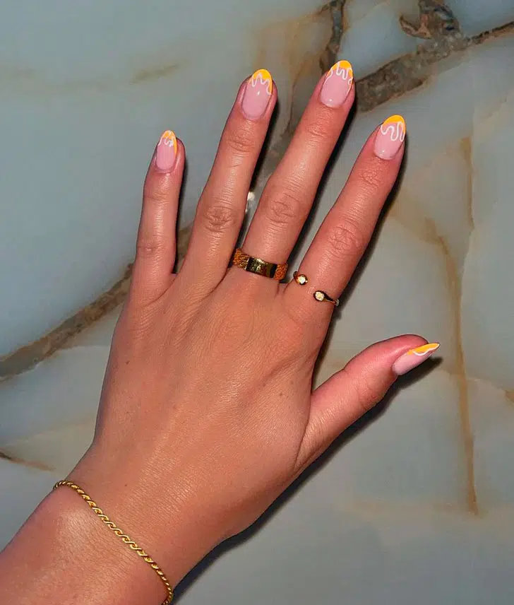 Желтый френч с белыми завитками на коротких овальных ногтях