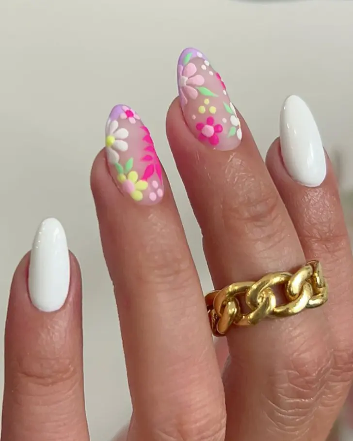 Белый маникюр с разноцветными цветами на овальных ногтях средней длины