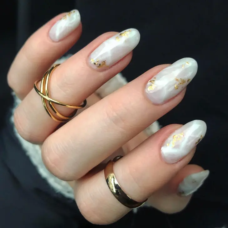 Белый маникюр с разводами и золотой фольгой на длинных овальных ногтях